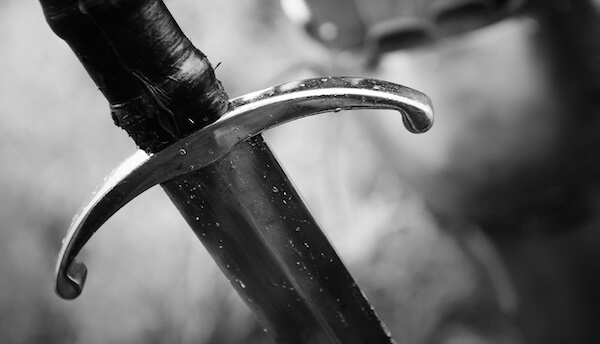 Medieval knight with sword in armor as style Game of Thrones in battle or tournament black and white old photo